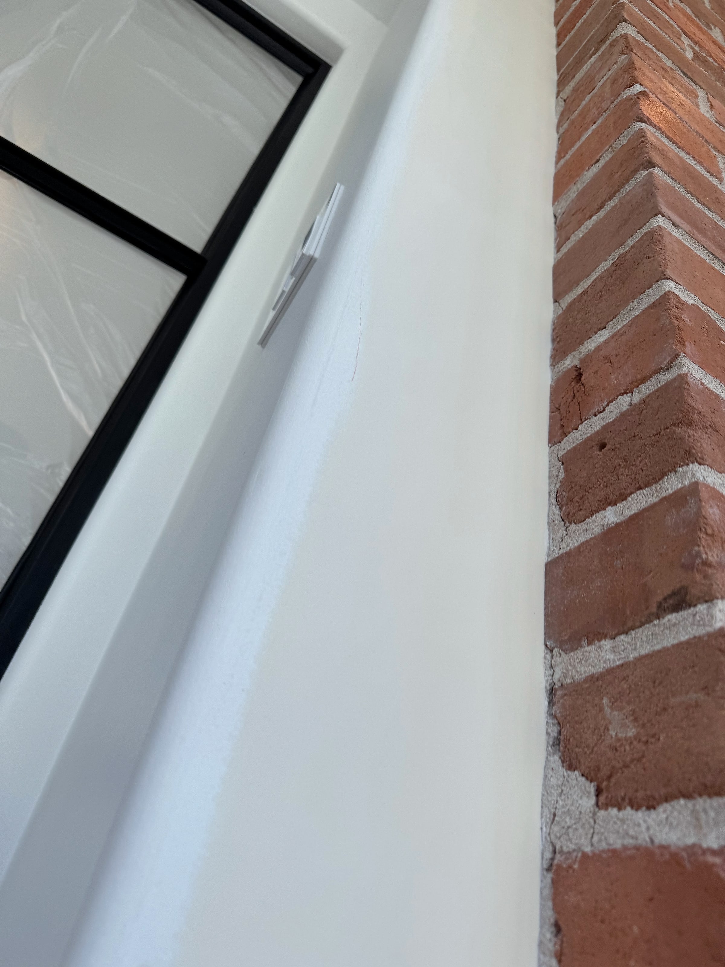 Drywall run up to an old brick wall
