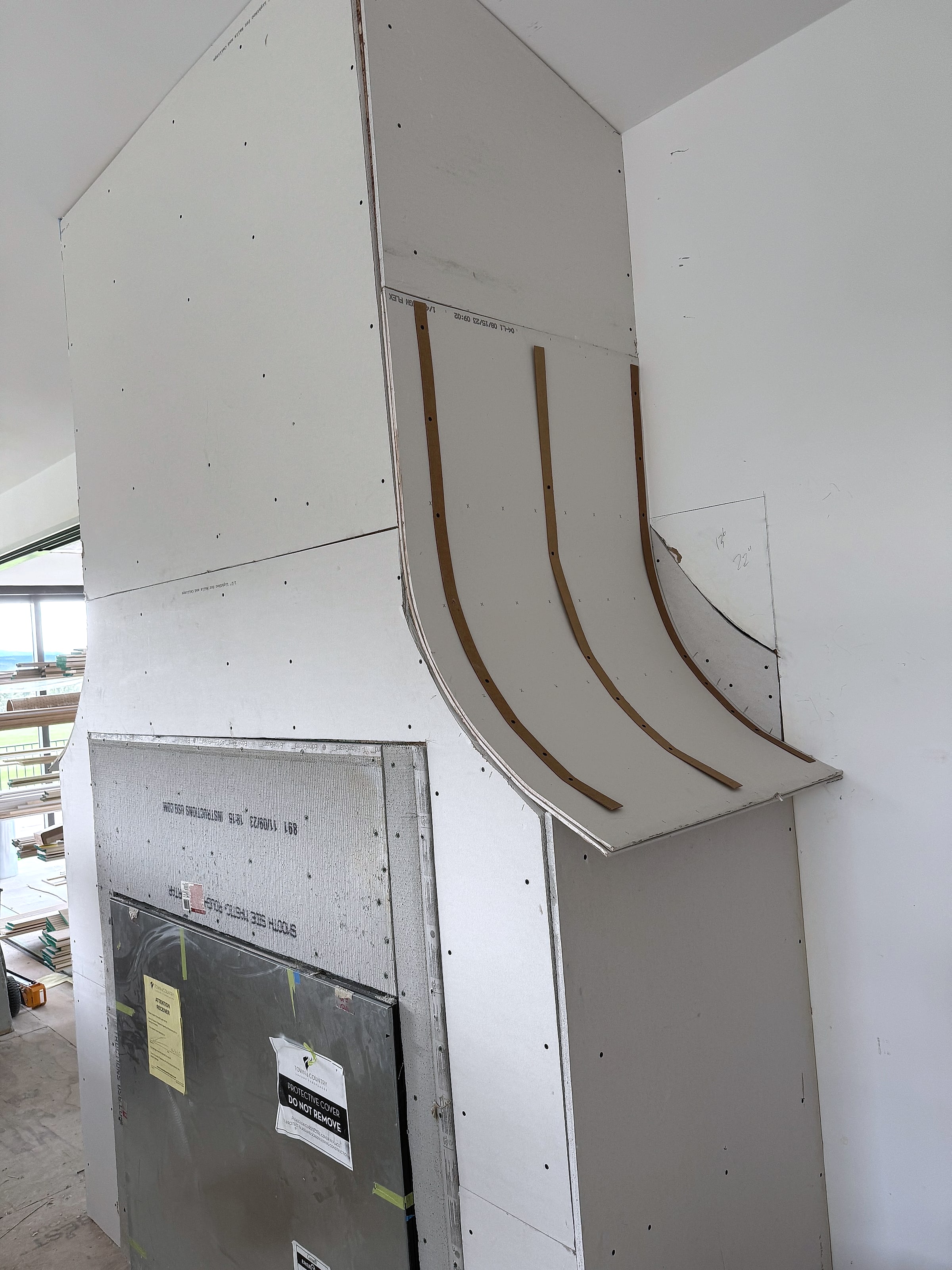 Drywall installed on a radius around a fireplace